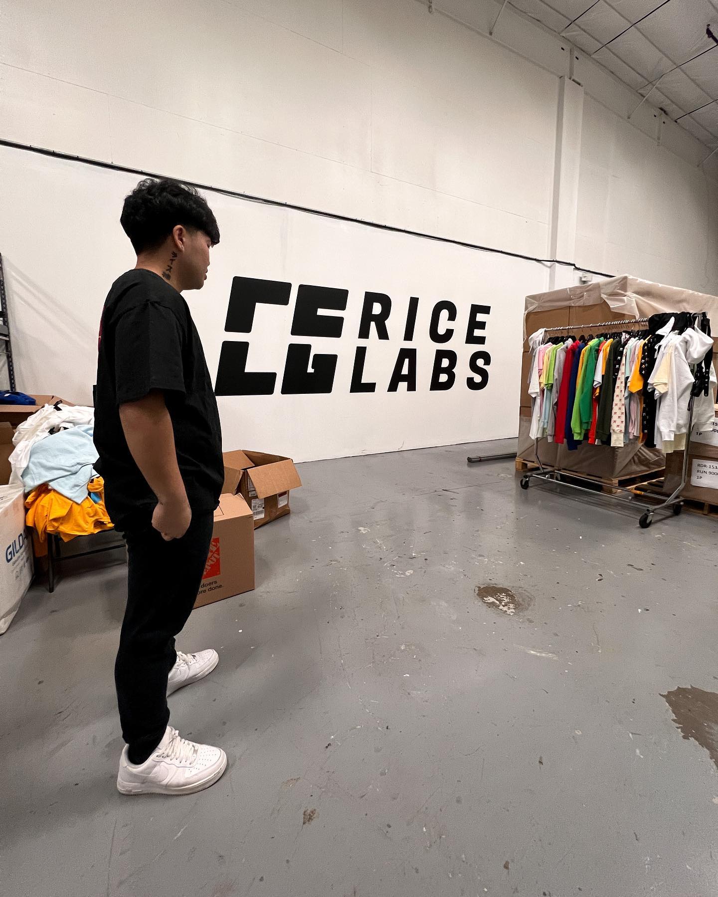 RICE LABS production floor with garment racks and the studio wall mark